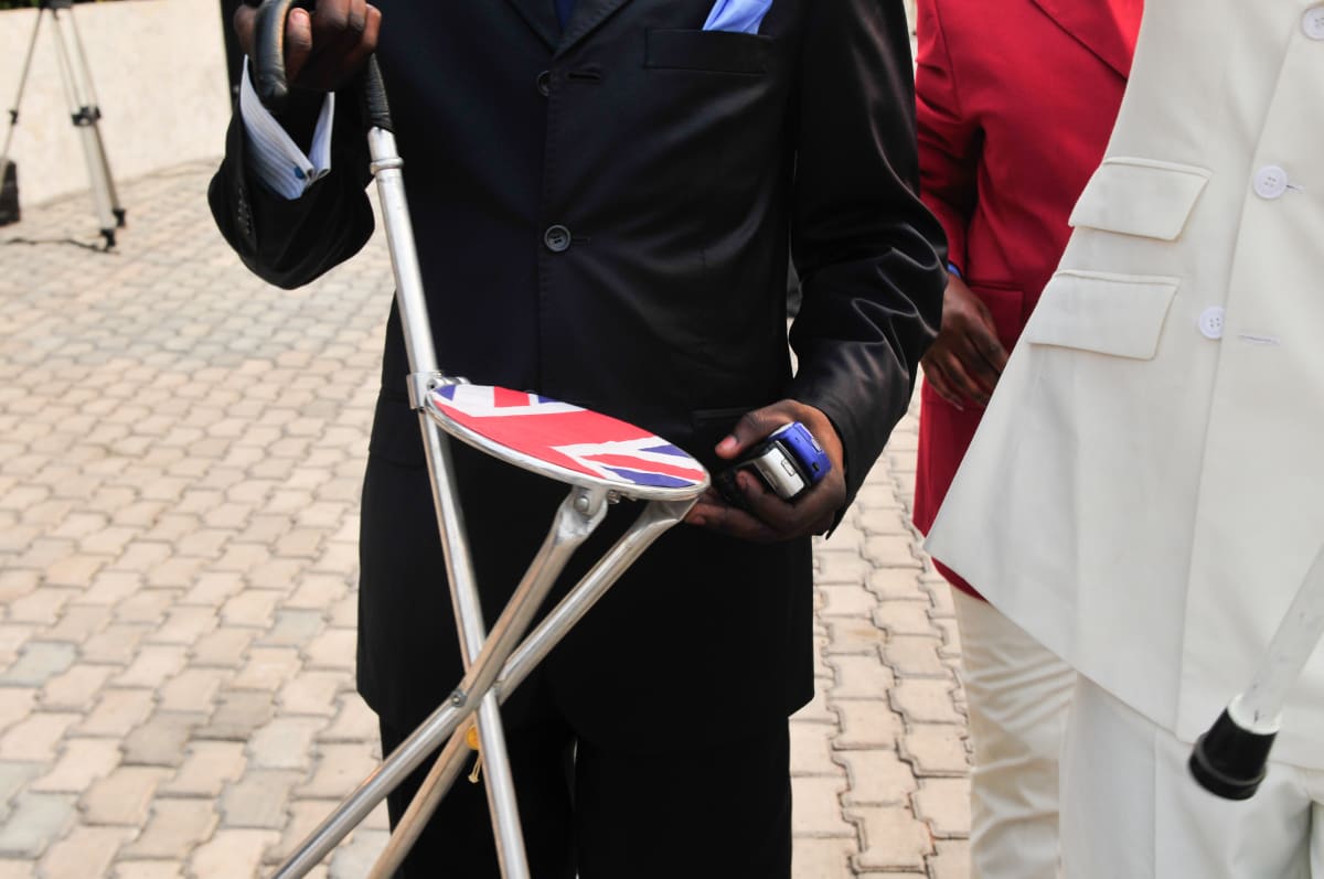 Untitled  Image: Sapeur showing his walking stick, which is also a retractable portable chair with the union jack printed on its seat. Brazzaville, Congo (2008)