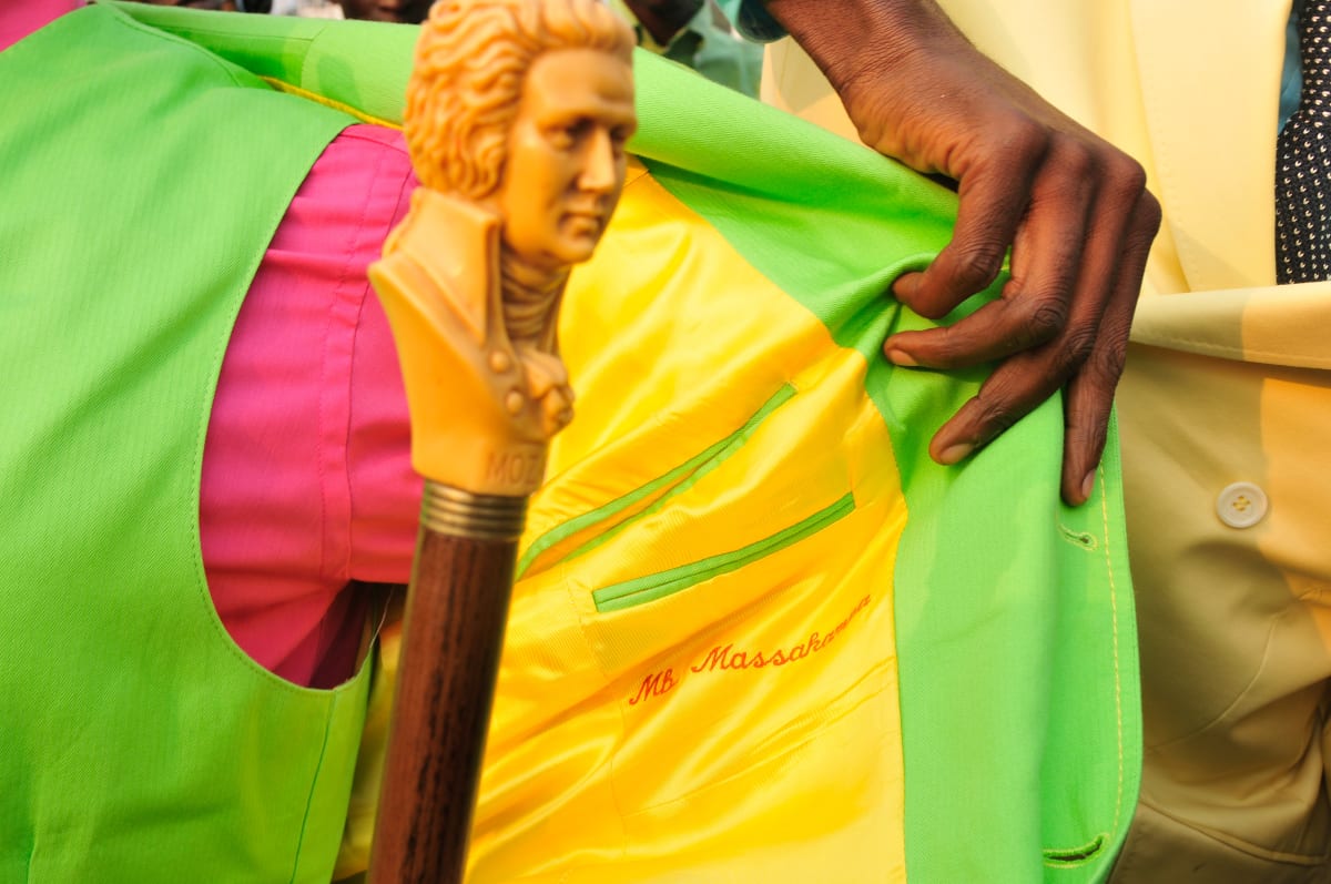 Untitled  Image: Sapeur Eric Massakampa showing the interior yellow lining of his green jacket, with his name, 'MB Massakampa' embroidered on it. His walking stick with a Mozart-carved handle is in the foreground, out of focus. Brazzaville, Congo (2008)