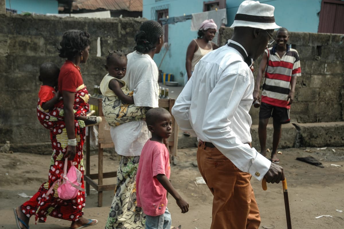 Untitled  Image: Michel walking down the street next to two moms with their kids. Brazzaville, Congo (2007)