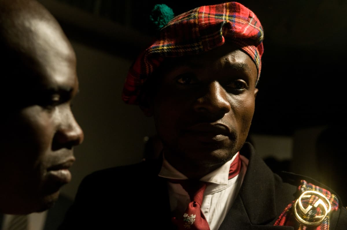 Untitled (Kevin, member of the Piccadilly Group)  Image: Portrait of Kevin, member of the Piccadilly Group, wearing a red tartan hat. Founded in 2001 by Ferol Ngouabi in the district of Moungali, the Piccadilly Group is famously innovative and was the first group to bring into fashion the Scottish kilt. Brazzaville, Congo (2008)