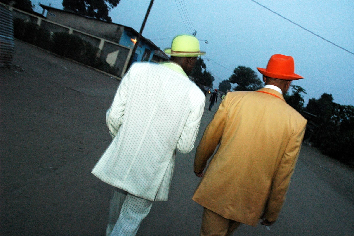 Untitled by Daniele Tamagni Foundation  Image: Kvv Mouzieto and his brother Ange Bienvenu Mouzieto walking towards a birthday party. Brazzaville, Congo (2007)