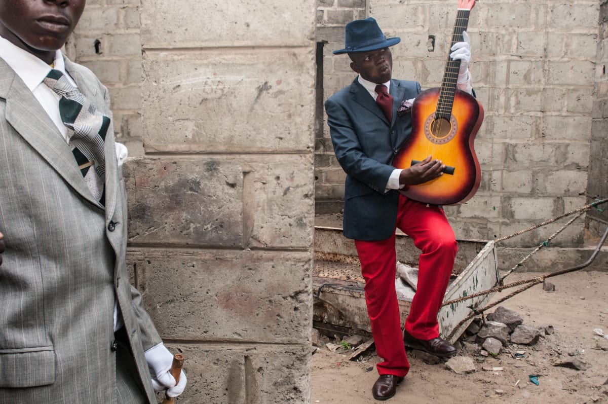 Untitled  Image: Two young Sapeurs, one in a grey suit and the other posing with his guitar. Brazzaville, Congo (2008)