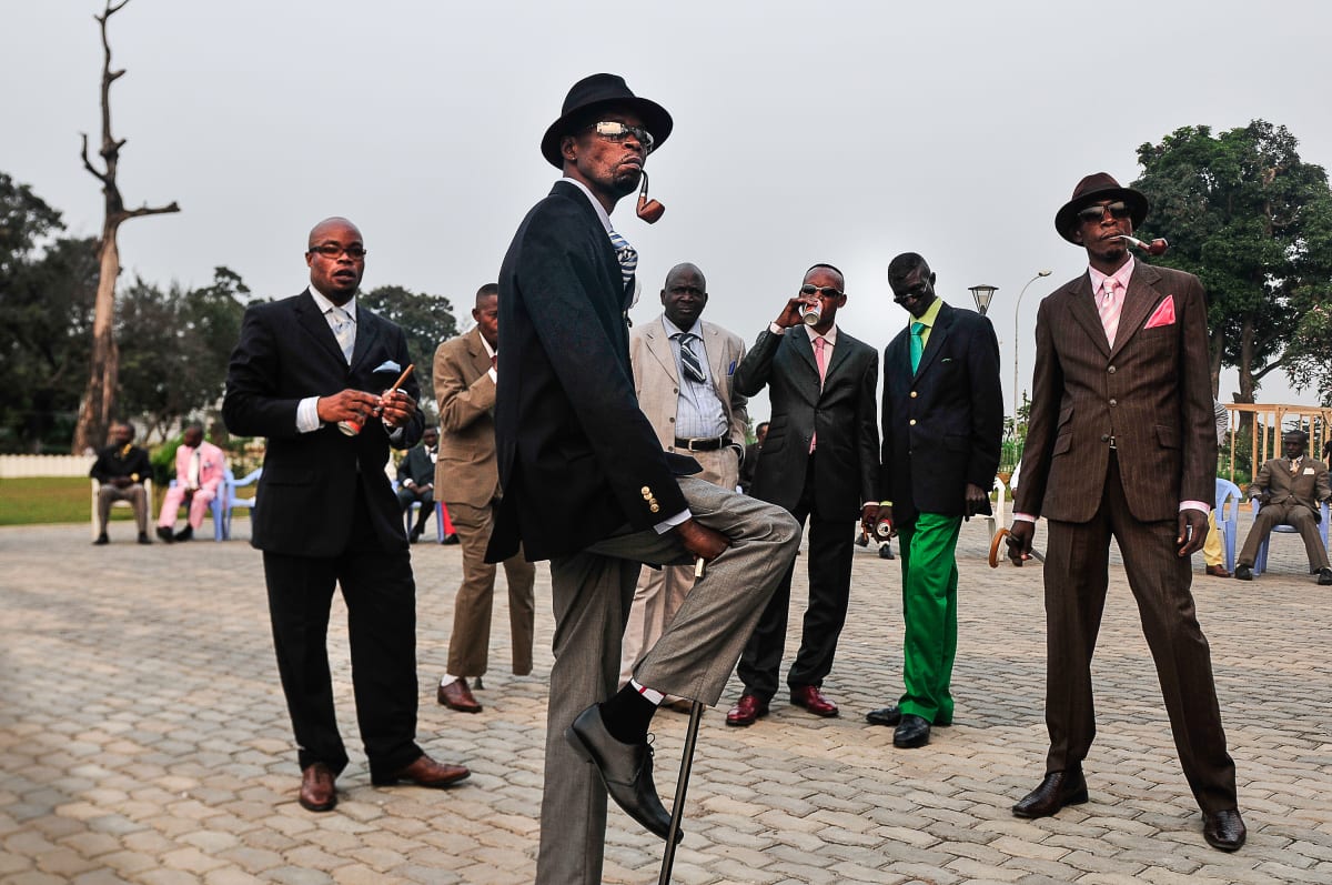 Untitled (Sapeurs posing in front of the memorial of Savorgnan de Brazza) by Daniele Tamagni Foundation  Image: Group of Sapeurs posing in front of the memorial of Pierre Savorgnan de Brazza, founder of the settlement that became Brazzaville. Brazzaville, Congo (2008)