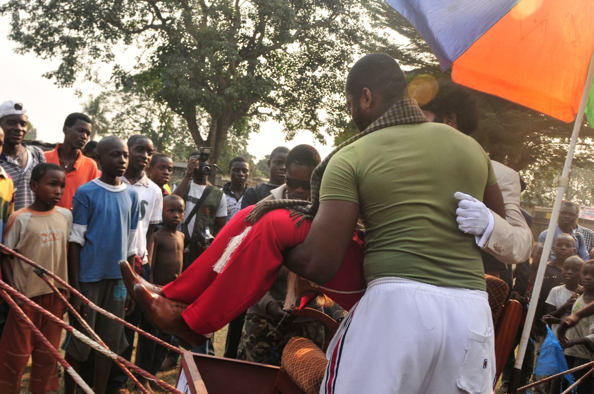 Untitled  Image: A Sapeur being placed on the charriot-throne of the 'Prince of Congo', surrounded by a watching crowd. Brazzaville, Congo (2008)