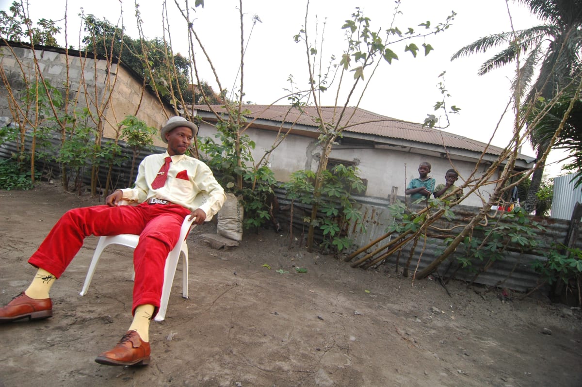 Untitled  Image: Gauthier, a Sapeur of Kinshasa, sitting on a plastic chair. Behind him, two curious children of Moungali. Brazzaville, Congo (2007)