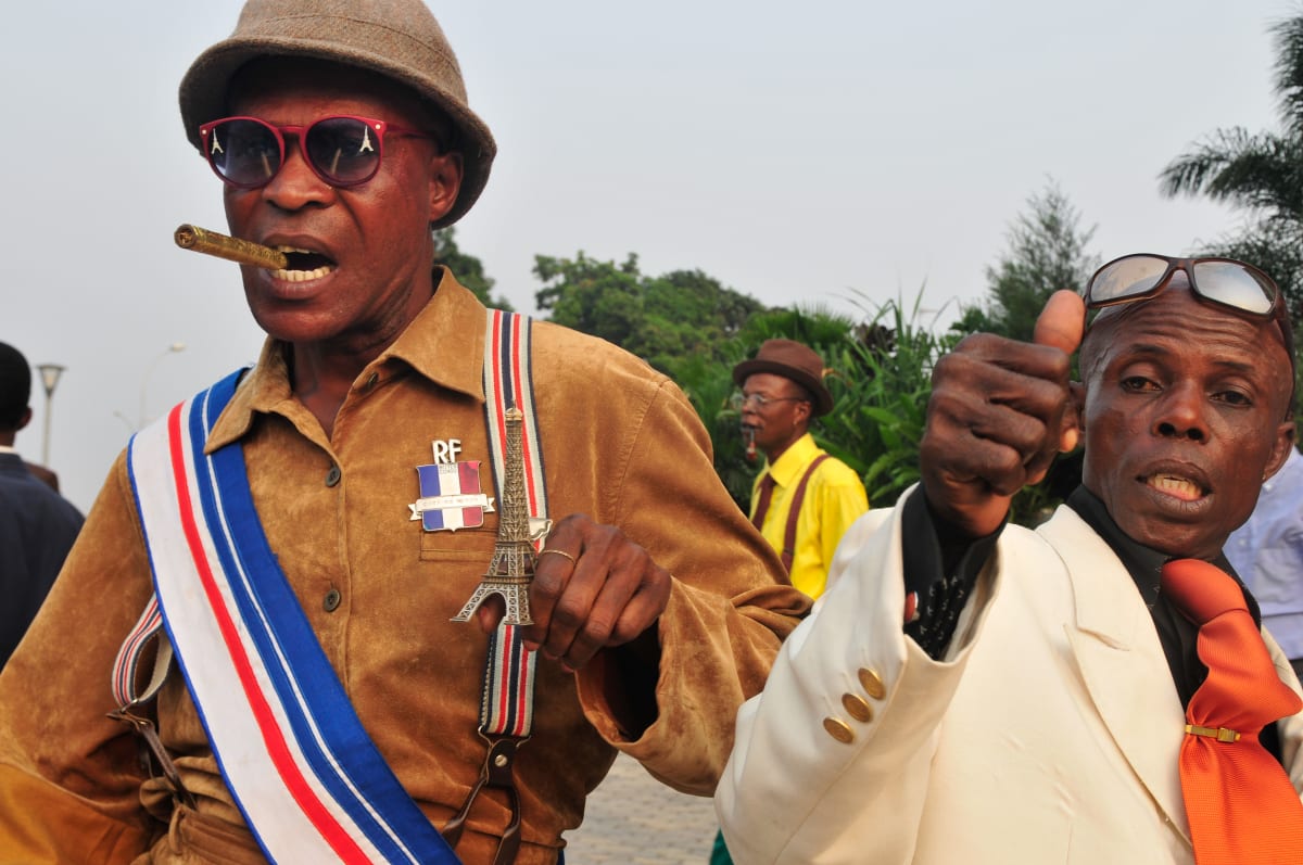 Untitled  Image: Man in French look-alike army uniform, bracers with the colors of the French flag, red sunglasses with the Tourre Eiffel printed on the lenses and cigar between his teeth. In his left hand, a statue of the Tourre Eiffel. Brazzaville, Congo (2008)