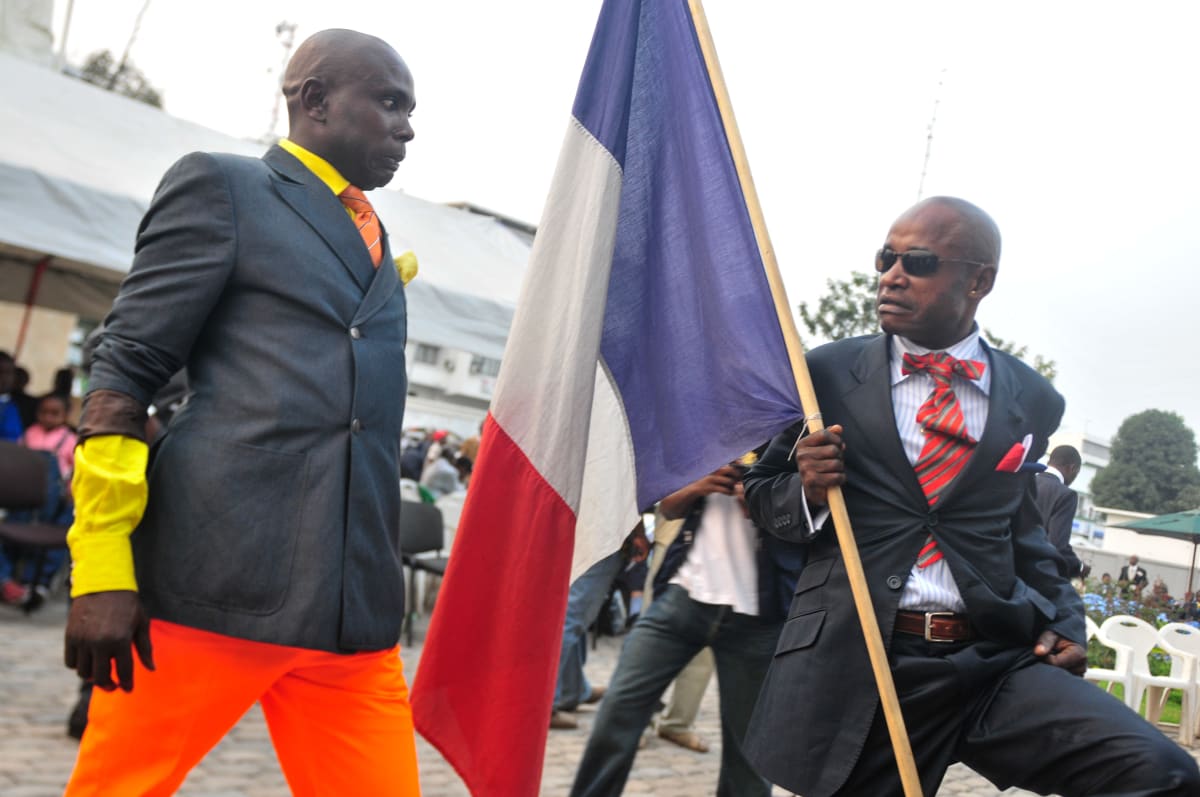 Untitled  Image: Two Sapeurs on the street, the one on the right holding the French flag. Brazzaville, Congo (2008)