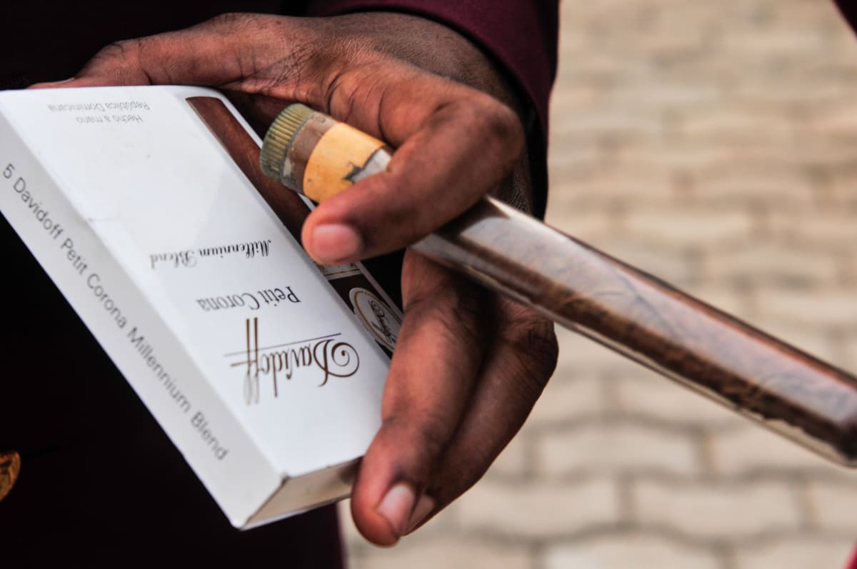 Untitled  Image: Close up shot of a hand holding a packet of Danidoff petit corona millennium blend cigars. Brazzaville, Congo (2008)