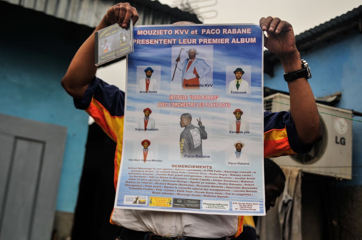 Untitled  Image: A man holding a poster advertising the launch of the first musica album by Kvv Mouzieto and Paco Rabane, "Sape Ezalie", with the Orchestra Les Plays Boys. Brazzaville, Congo (2008)