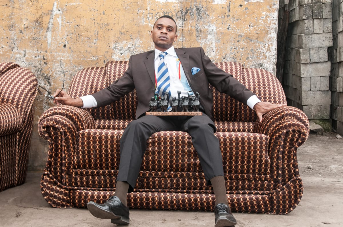 Untitled  Image: Samba La Mairie sitting on a couch with the 'Best Sapeur 2007' trophy on his lap. Brazzaville, Congo (2008)
