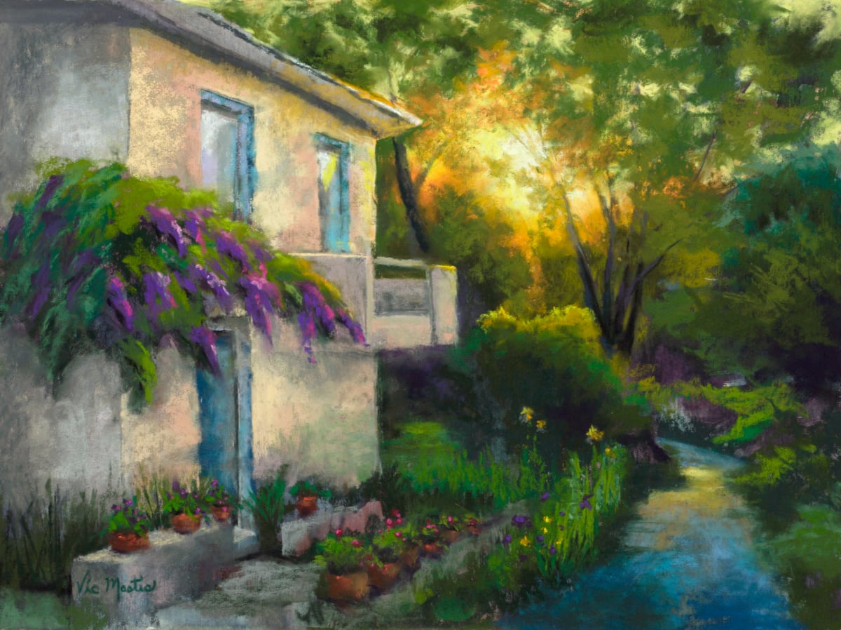 Wisteria Walk by Vic Mastis  Image: While I was at the workshop in Southern France,  I would go for an early morning walk.  I would pass this old bungalow with the old lady outside watering her plants.  The sun was just rising and showing through the trees making this beautiful scene. 