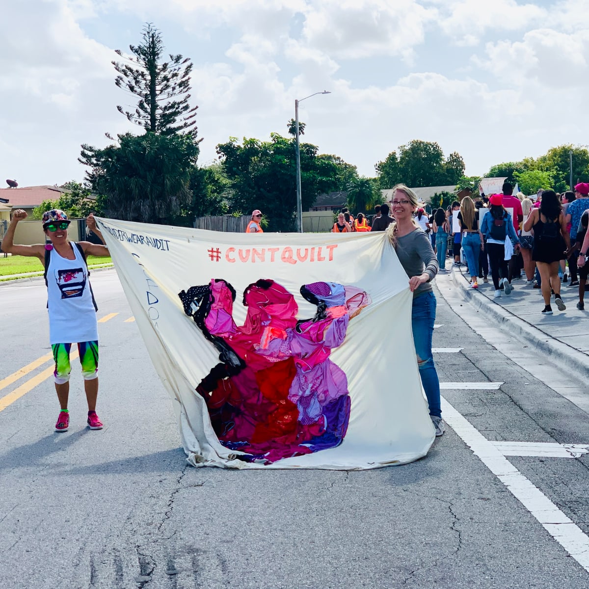 Arpillera Americanx * Cunt Quilt (Silueta) Cunt Congress by Coralina Rodriguez Meyer  Image: Artist Coralina Rodriguez Meyer & educator Andrea Preston bear the Arpillera Americanx * Cunt Quilt (Silueta) sanctuary city flag on their backs during the Power to the Polls Womens March Miami protest January 18, 2020 in Miami Gardens FL