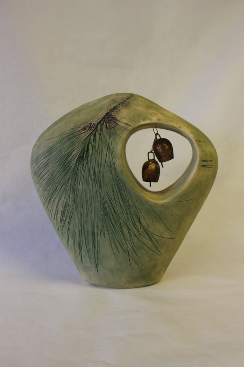 Pine with Bells by Linda G. Bunch  Image: Hand built clay vessel with impressed pine design. Opening with two small brass bells. Glazed matt white interior. Oxide washes on outside to enhance the impressed design.