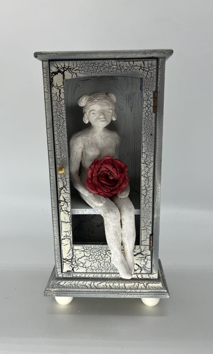 Out of the Box by Patricia Isenhour  Image: Ceramic woman figure in an upcycled wooden box holding a ceramic rose