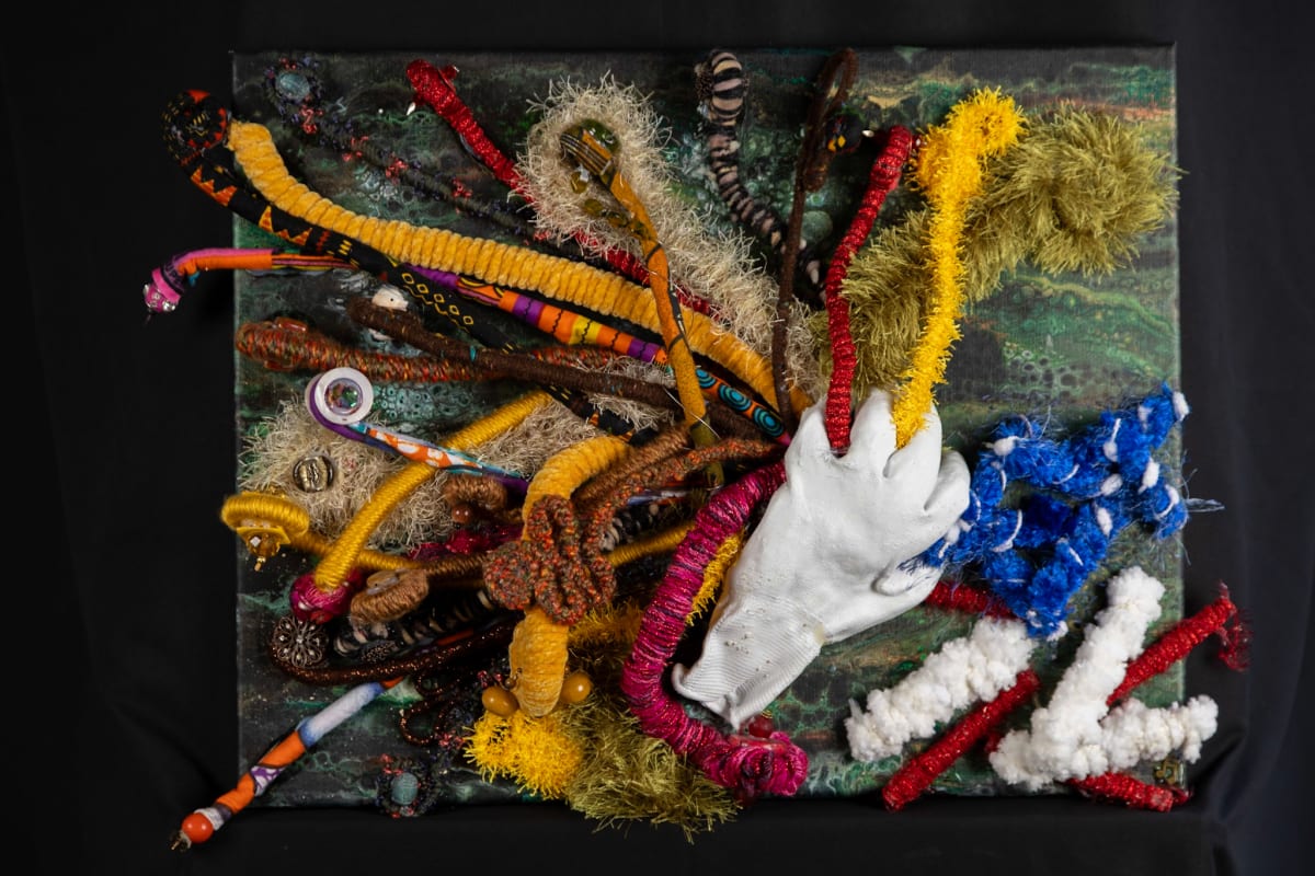 Broken Promises Dashed Dreams by Dellis Frank  Image: Broken Promises Dashed Dreams - From the time the others stepped foot on this land claiming it as their own, inequities existed. This piece represents the broken promises of treaties, emancipation, fair immigration, and protection for all being crushed by the white hand. The rich colors and textures of the fibers, and the beauty, denote the diverse peoples that bring an abundance of culture and color to our world