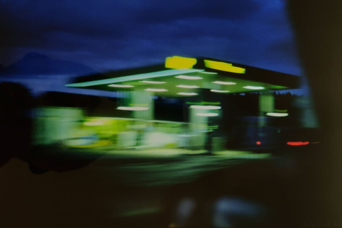 rest stop by Heather Lewis  Image: Gas stations are beacons of light on dark, winter nights. The blur gives the sense of passing at speed, which is part of my goal. 