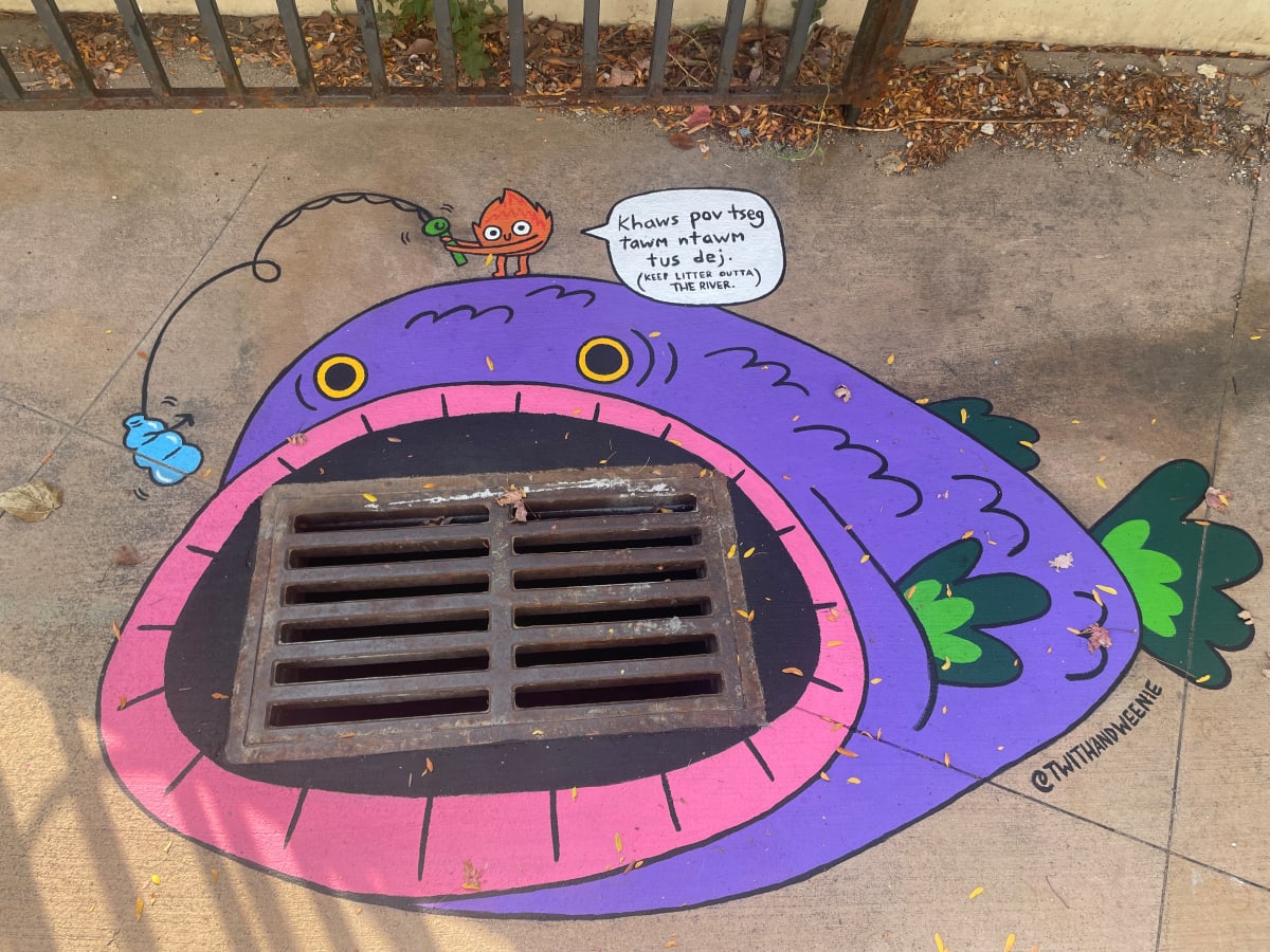 Storm Drain Art: Remembering the Cannon by Rocky Casillas  Image: Text is in Hmong: "Keep waste out of the water"