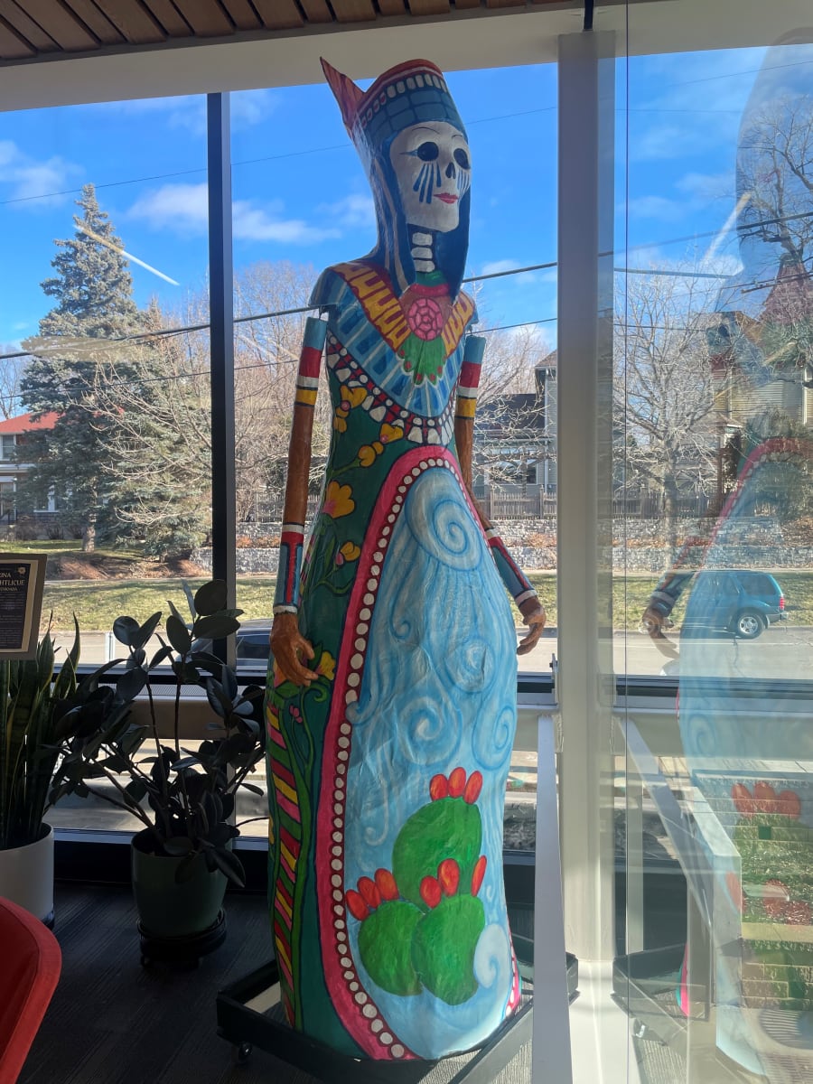 The Catrina Chalchiuhtlicue by Gustavo Boada  Image: One large-scale, interactive sculptural piece representing Latino popular culture (“Catrina”) at the Northfield Public Library. Catrina’s clothing symbolizes that of Chalchiuhtlicue, a protective goddess of water. This sculpture aims to connect Northfield’s Latino community with their ancestors while also serving as a reminder of water as a legacy and source of life for new generations.