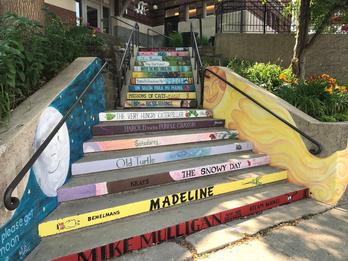 Literary Steps by Kathy Ness, Kate Woodstrup  Image: Painted replicas of children’s book spines (with titles crowdsourced from the community) on the 16 steps going up to the Division St. side of the Northfield Public Library.