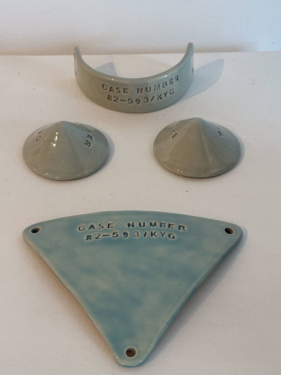 Case Number 82-593/KYG Armor 4 piece set by kayla tange  Image: Kayla Tange's adoption number on ceramic set. Includes signed photograph shot by Luka Fisher of Kayla wearing the set.