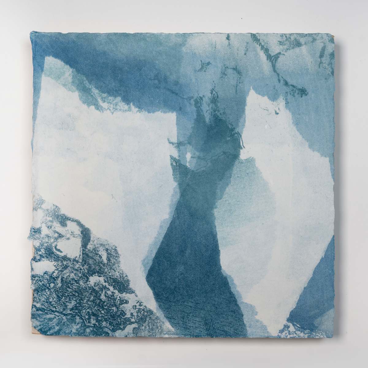 Ice Watch Studies #12 by Megan Broughton  Image: A series of experimental etchings evoking atmospheric Arctic seascapes. These pieces were made in memory of ice watches during the MaréMotrice artist residency in Greenland, sailing through foggy fjords. They function like a brilliant, shapeshifting, reveal through the fog and play with Arctic mirages and cause tricks of the eye. There are moments of clear detail and sublime wonder amidst fragmentation. Two etching plates were printed over each other multiple times in different orientations to create new and abstracted imagery. Stencils made of torn newsprint were used to block ink during the printing process, creating the white shapes throughout the works. The stencils were continually torn apart and reused throughout the series so that the stencil shapes become self-referential but are constantly transforming and deteriorating. Mounted on a cradled wooden panel.