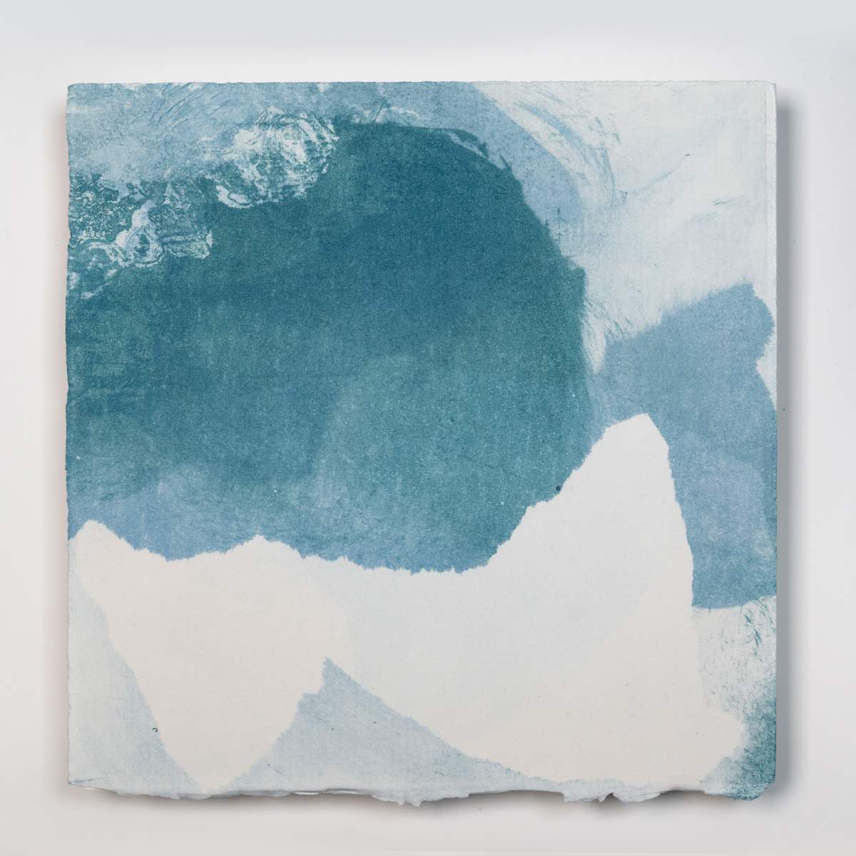 Ice Watch Studies #23 by Megan Broughton  Image: A series of experimental etchings evoking atmospheric Arctic seascapes. These pieces were made in memory of ice watches during the MaréMotrice artist residency in Greenland, sailing through foggy fjords. They function like a brilliant, shapeshifting, reveal through the fog and play with Arctic mirages and cause tricks of the eye. There are moments of clear detail and sublime wonder amidst fragmentation. Two etching plates were printed over each other multiple times in different orientations to create new and abstracted imagery. Stencils made of torn newsprint were used to block ink during the printing process, creating the white shapes throughout the works. The stencils were continually torn apart and reused throughout the series so that the stencil shapes become self-referential but are constantly transforming and deteriorating. Mounted on a cradled wooden panel.