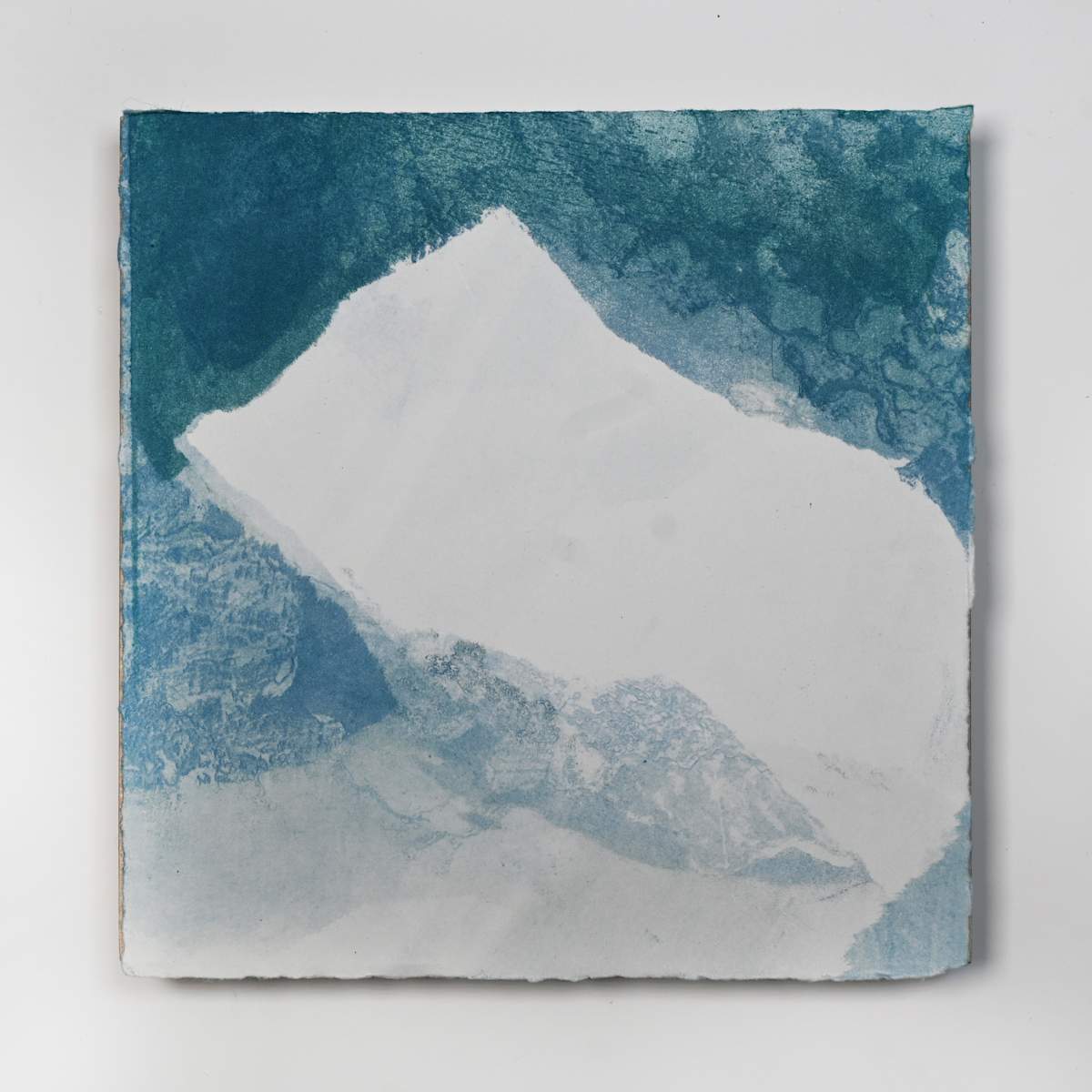 Ice Watch Studies #37 by Megan Broughton  Image: A series of experimental etchings evoking atmospheric Arctic seascapes. These pieces were made in memory of ice watches during the MaréMotrice artist residency in Greenland, sailing through foggy fjords. They function like a brilliant, shapeshifting, reveal through the fog and play with Arctic mirages and cause tricks of the eye. There are moments of clear detail and sublime wonder amidst fragmentation. Two etching plates were printed over each other multiple times in different orientations to create new and abstracted imagery. Stencils made of torn newsprint were used to block ink during the printing process, creating the white shapes throughout the works. The stencils were continually torn apart and reused throughout the series so that the stencil shapes become self-referential but are constantly transforming and deteriorating. Mounted on a cradled wooden panel.