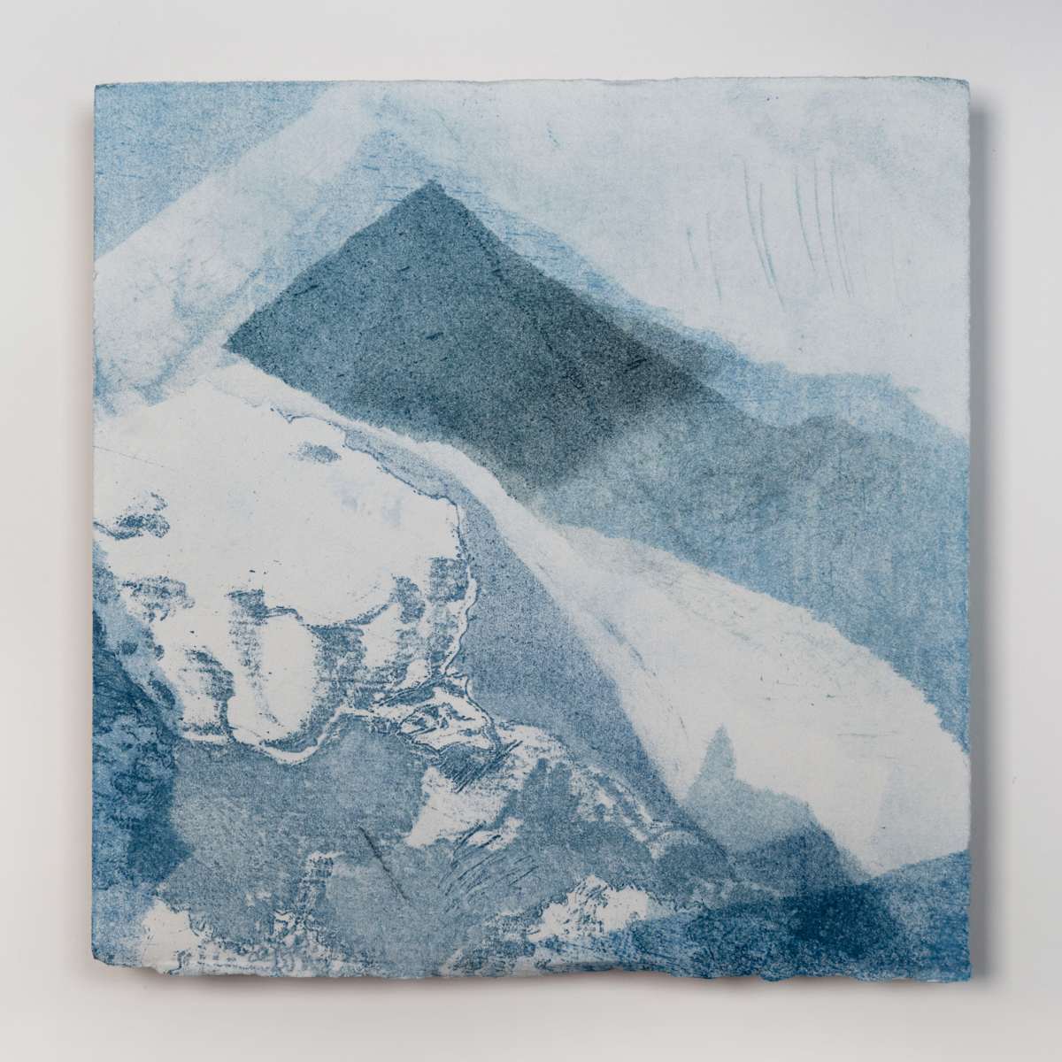Ice Watch Studies #3 by Megan Broughton  Image: A series of experimental etchings evoking atmospheric Arctic seascapes. These pieces were made in memory of ice watches during the MaréMotrice artist residency in Greenland, sailing through foggy fjords. They function like a brilliant, shapeshifting, reveal through the fog and play with Arctic mirages and cause tricks of the eye. There are moments of clear detail and sublime wonder amidst fragmentation. Two etching plates were printed over each other multiple times in different orientations to create new and abstracted imagery. Stencils made of torn newsprint were used to block ink during the printing process, creating the white shapes throughout the works. The stencils were continually torn apart and reused throughout the series so that the stencil shapes become self-referential but are constantly transforming and deteriorating. Mounted on a cradled wooden panel.