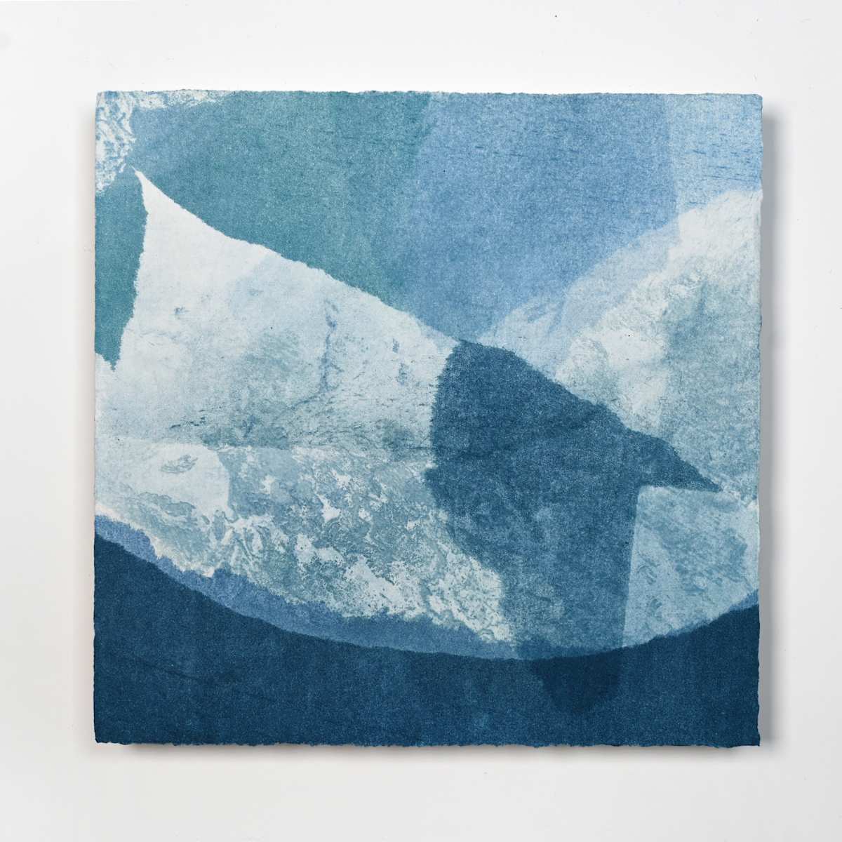 Ice Watch Studies #45 by Megan Broughton  Image: A series of experimental etchings evoking atmospheric Arctic seascapes. These pieces were made in memory of ice watches during the MaréMotrice artist residency in Greenland, sailing through foggy fjords. They function like a brilliant, shapeshifting, reveal through the fog and play with Arctic mirages and cause tricks of the eye. There are moments of clear detail and sublime wonder amidst fragmentation. Two etching plates were printed over each other multiple times in different orientations to create new and abstracted imagery. Stencils made of torn newsprint were used to block ink during the printing process, creating the white shapes throughout the works. The stencils were continually torn apart and reused throughout the series so that the stencil shapes become self-referential but are constantly transforming and deteriorating. Mounted on a cradled wooden panel.