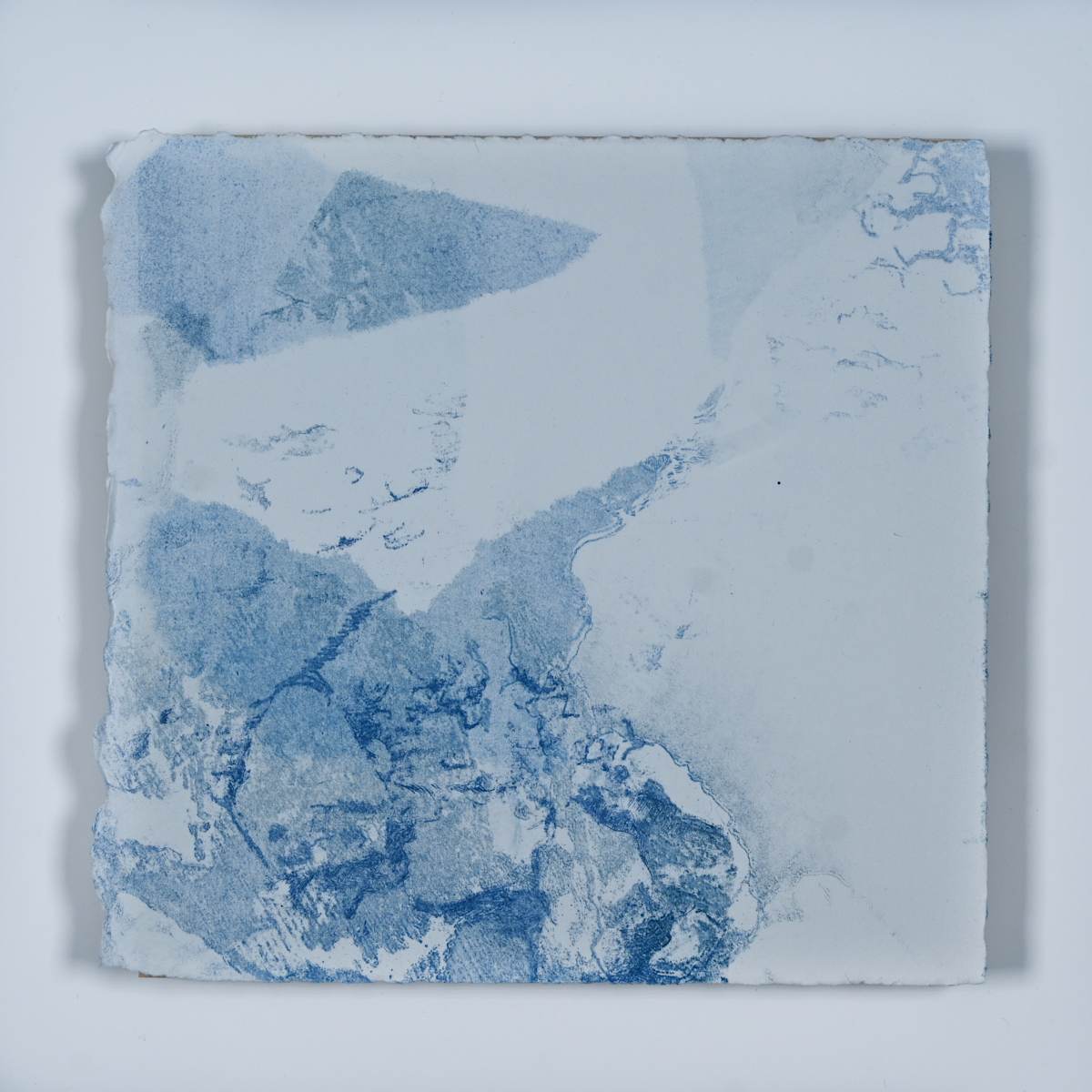 Ice Watch Studies #71 by Megan Broughton  Image: A series of experimental etchings evoking atmospheric Arctic seascapes. These pieces were made in memory of ice watches during the MaréMotrice artist residency in Greenland, sailing through foggy fjords. They function like a brilliant, shapeshifting, reveal through the fog and play with Arctic mirages and cause tricks of the eye. There are moments of clear detail and sublime wonder amidst fragmentation. Two etching plates were printed over each other multiple times in different orientations to create new and abstracted imagery. Stencils made of torn newsprint were used to block ink during the printing process, creating the white shapes throughout the works. The stencils were continually torn apart and reused throughout the series so that the stencil shapes become self-referential but are constantly transforming and deteriorating.