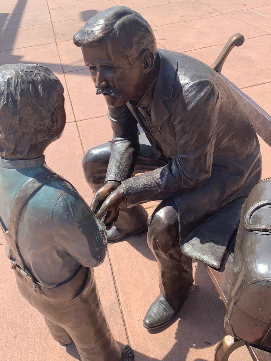 Dr. Walter Heath Street Call (Permanent Public Art) by Don Budy  Image: A bronze statue of Dr. Walter Heath, an integral character in Parker history, is displayed on the northeast corner of Mainstreet and Pikes Peak Place. Created by local artist Don Budy, this project was made possible by Parker Adventist Hospital, Dr. Heath’s grandchildren, Edward V. Heath and Clair Heath Fink, David A. Van Landschoot and Stevan Strain.