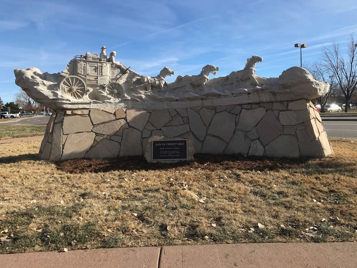 Run to Twenty Mile (Permanent Public Art) by Ralph Crawford  Image: Run to Twenty Mile by Ralph Crawford was installed March 20, 2000 at Living Wheel Park, located at the intersection of Mainstreet and Stage Run. The sculpture depicts a stagecoach with six horses, and driver in the likeness of Wild Bill Hickok. Riding shotgun is the sculptor himself with Annie Oakley and Buffalo Bill in the stagecoach.