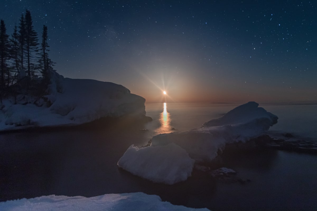 Grand Marais, MN by Earl Todd  Image: The plan was to shoot the Milky Way up until moonrise; we just needed a place. While searching on Google for a location, we noticed this small island along the Lake Superior shore, so we pulled off and hiked in. As the moon started rising, the Milky Way began to wash out, so I moved to watch the moonrise. If you are familiar with constellations, you will notice Scorpio to the right side of the image.