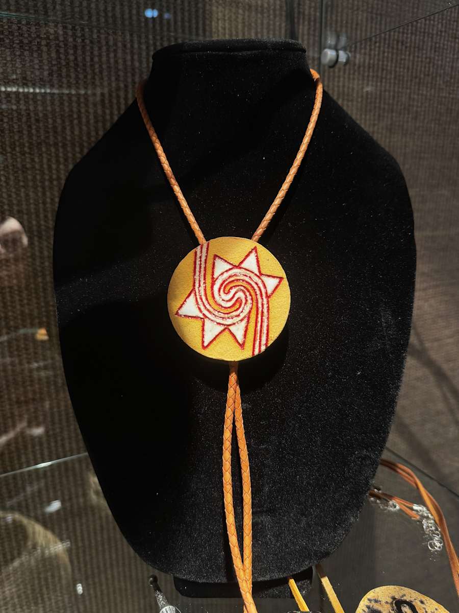 Wind Bolo by Jay Laxton  Image: Ceramic bolo tie with wind symbol