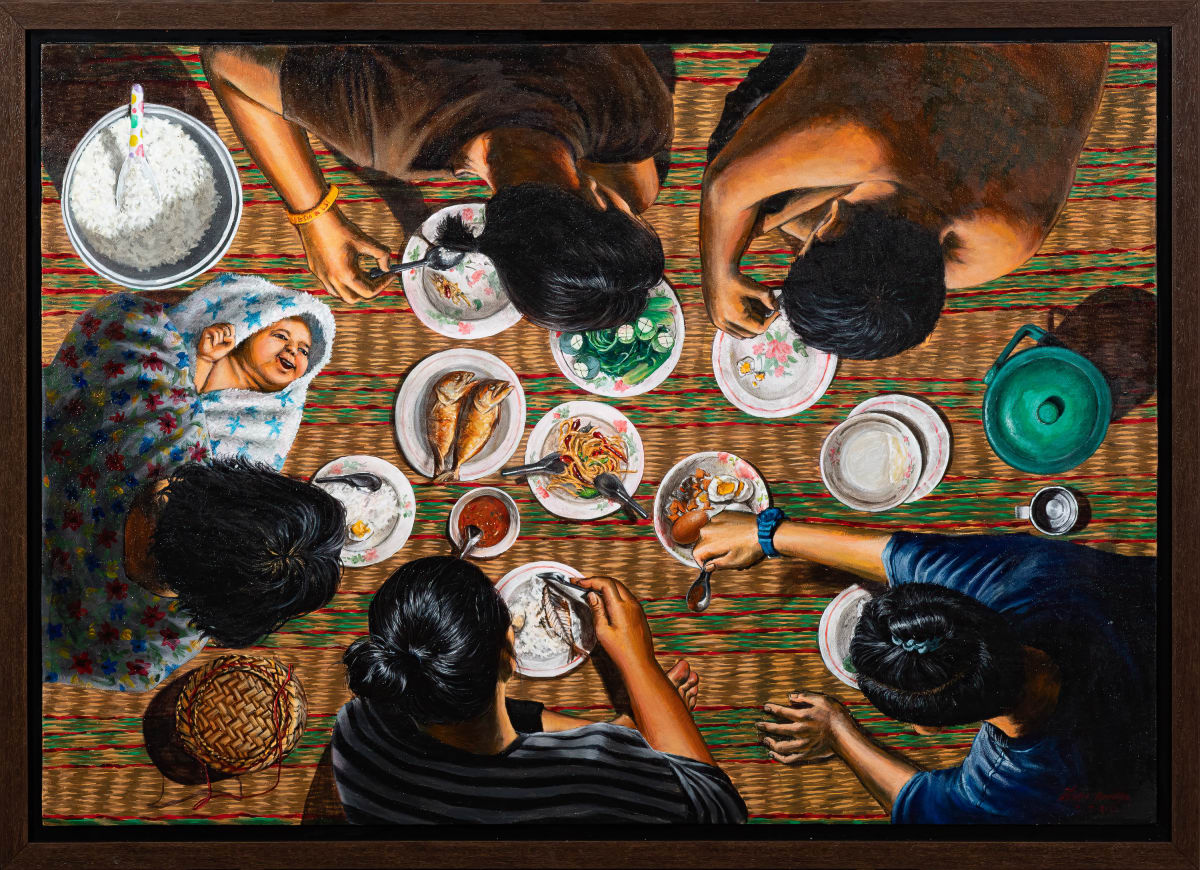 ST045 (ความสุขในวงกินข้าว) by Sakda Thipsuk  Image: What is appealing about this image, and why we chose to display it, is that it is an accurate representation of Thai dining culture that cannot be mistaken for anything else. Although some of the elements in the image may remind you of modern times, sitting on a mattress and dining with friends and family is a common ritual that dates back to the beginning of civilization. The food is varied and was designed to be shared; such activity may have a Christmas feel to Western eyes, but it is a daily-basis activity among Thais (and Southeast Asians in general) even to this day.