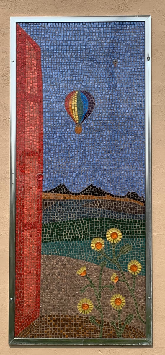 The Three Sisters by Dina Afek  Image: The three sisters are three extinct volcanoes on the west side of Albuquerque. This piece is what I imagine I would see if I had a clear view from my house.  Because I finished it in June, the balloon has the pride flag colors.  In addition,  this piece reminds me that I have three sisters, all who live far away. 