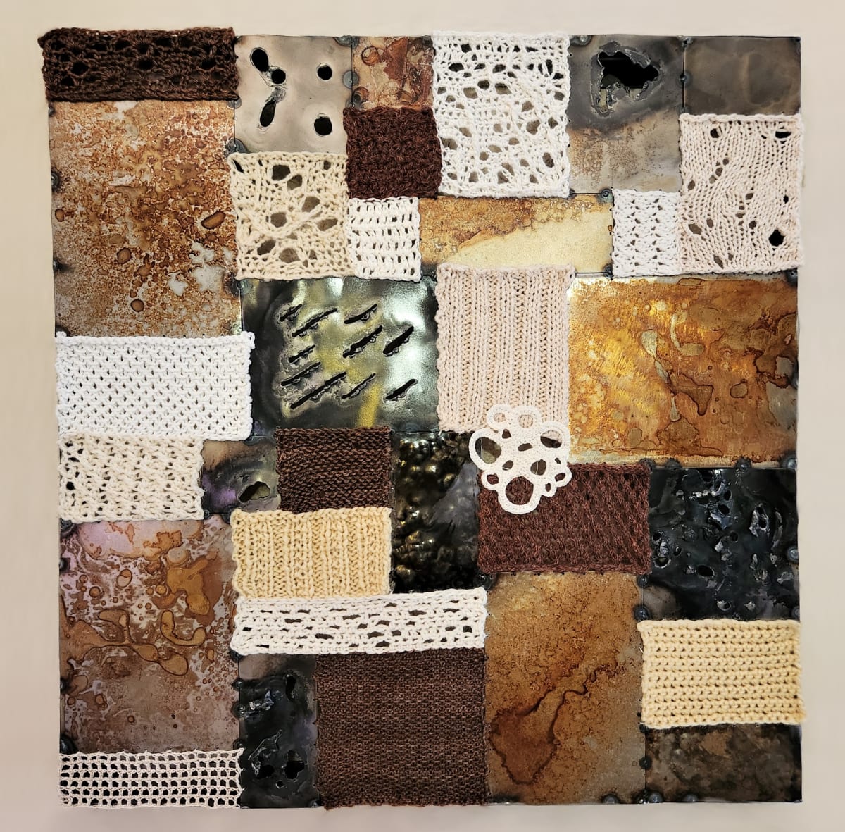 Assembly by Amanda Langer  Image: Square steel and fiber wall hanging. Surface made of quilt-like arrangement of steel and fiber pieces. Steel surfaces vary in color, shine, rust pattern, and texture. Fiber pieces vary in color, pattern, fiber content, and texture.