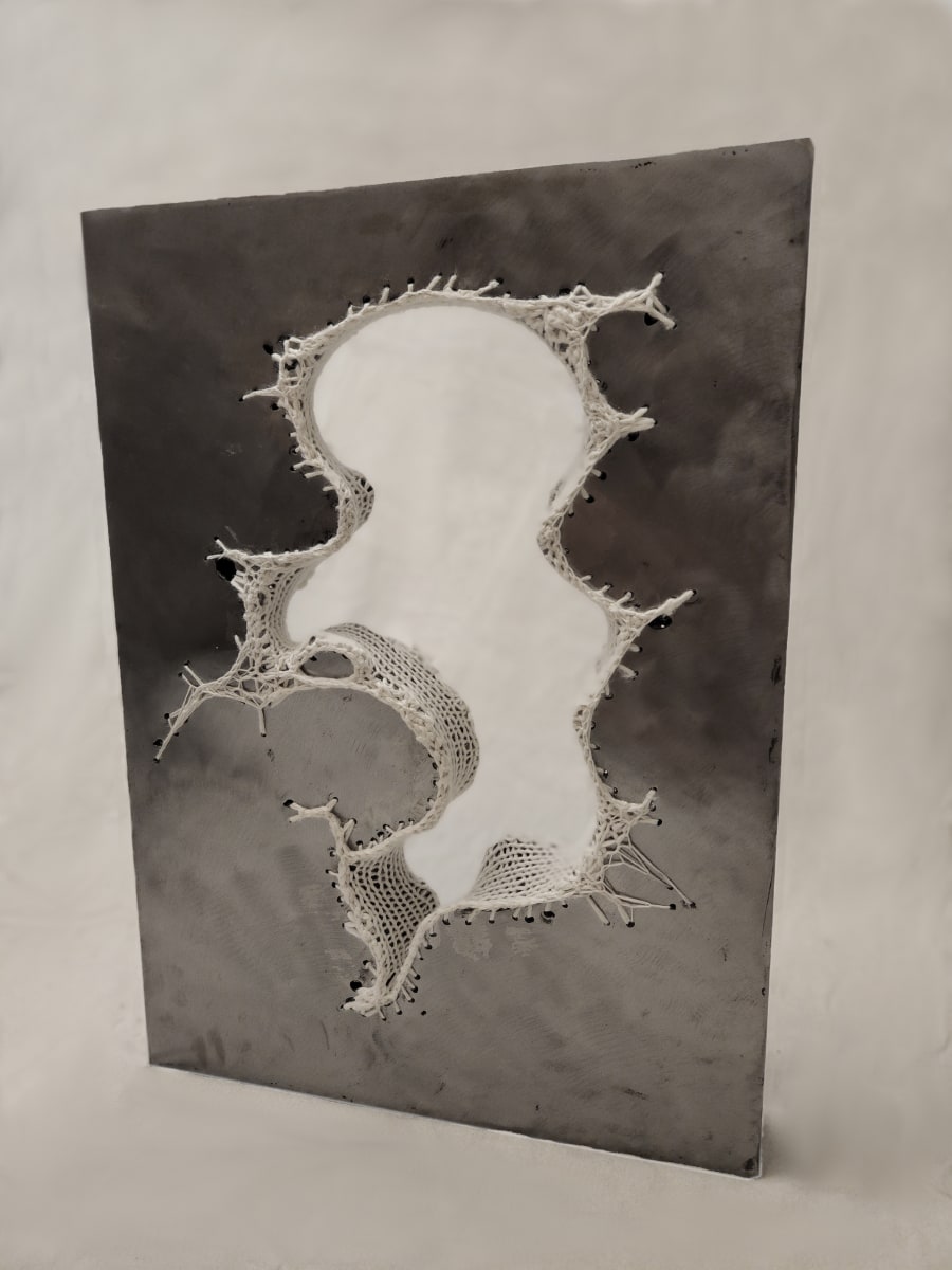 Interior by Amanda Langer  Image: Rectangular steel slab features large abstract organic hole through middle. Hole is lined with knitted wool yarn. Crocheted yarn "grows" away from hole over surface of steel.