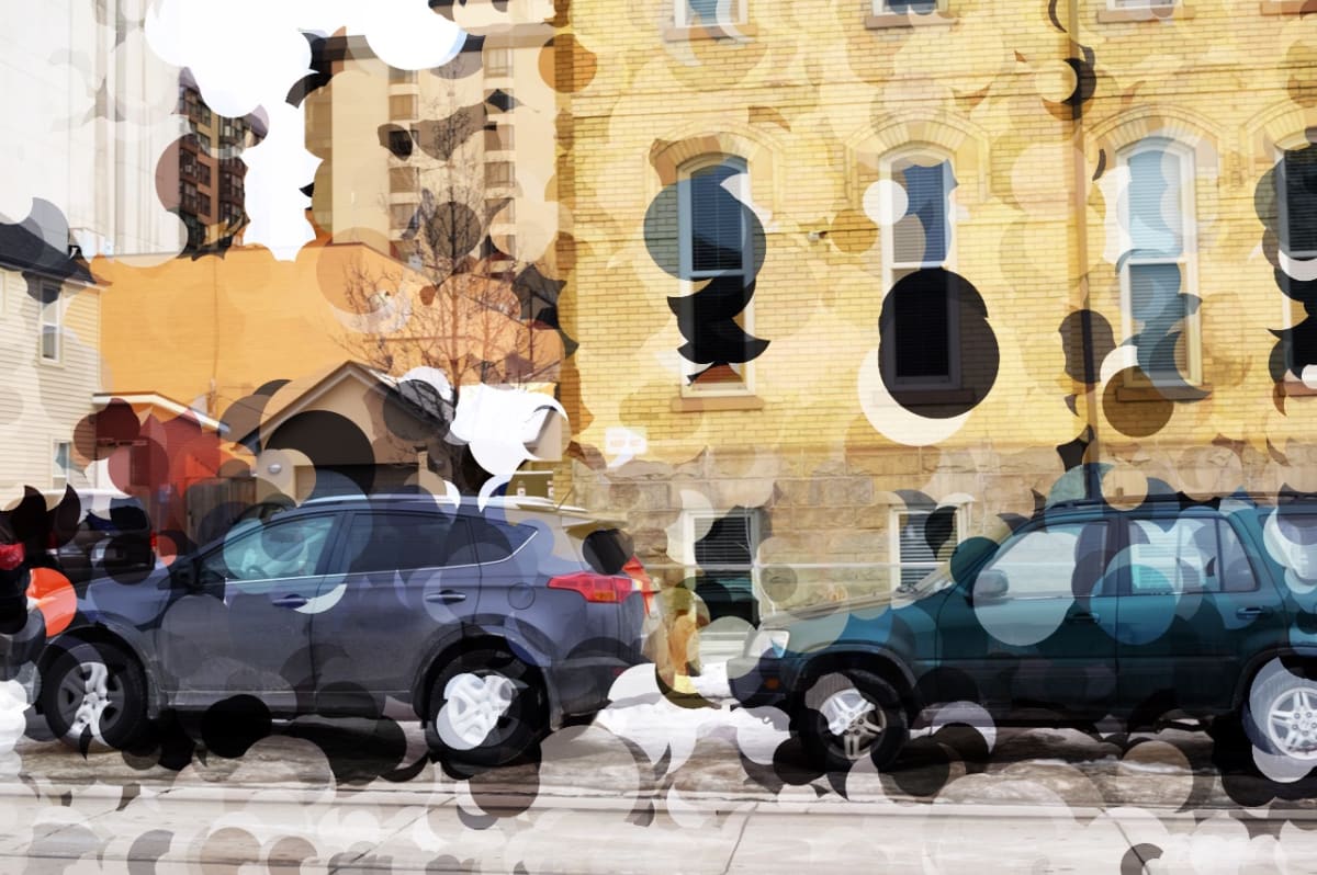 Urban Veil by Emily Rose Govier Honderich  Image: Urban Veil merges photographic realism with abstract digital intervention. The underlying image—a quiet urban street scene featuring parked cars and warm-toned buildings—is partially obscured by layered circular shapes and semi-transparent textures. These abstract overlays distort the image like a veil, challenging the viewer’s perception of space, clarity, and urban identity. The composition reflects themes of anonymity, memory, and the visual noise of modern environments.