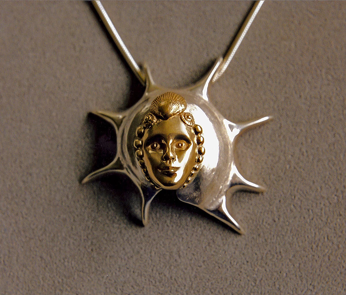 Shell Maiden by Artist Aimee J  Image: Gold face of maiden with a silver shell surrounding her.