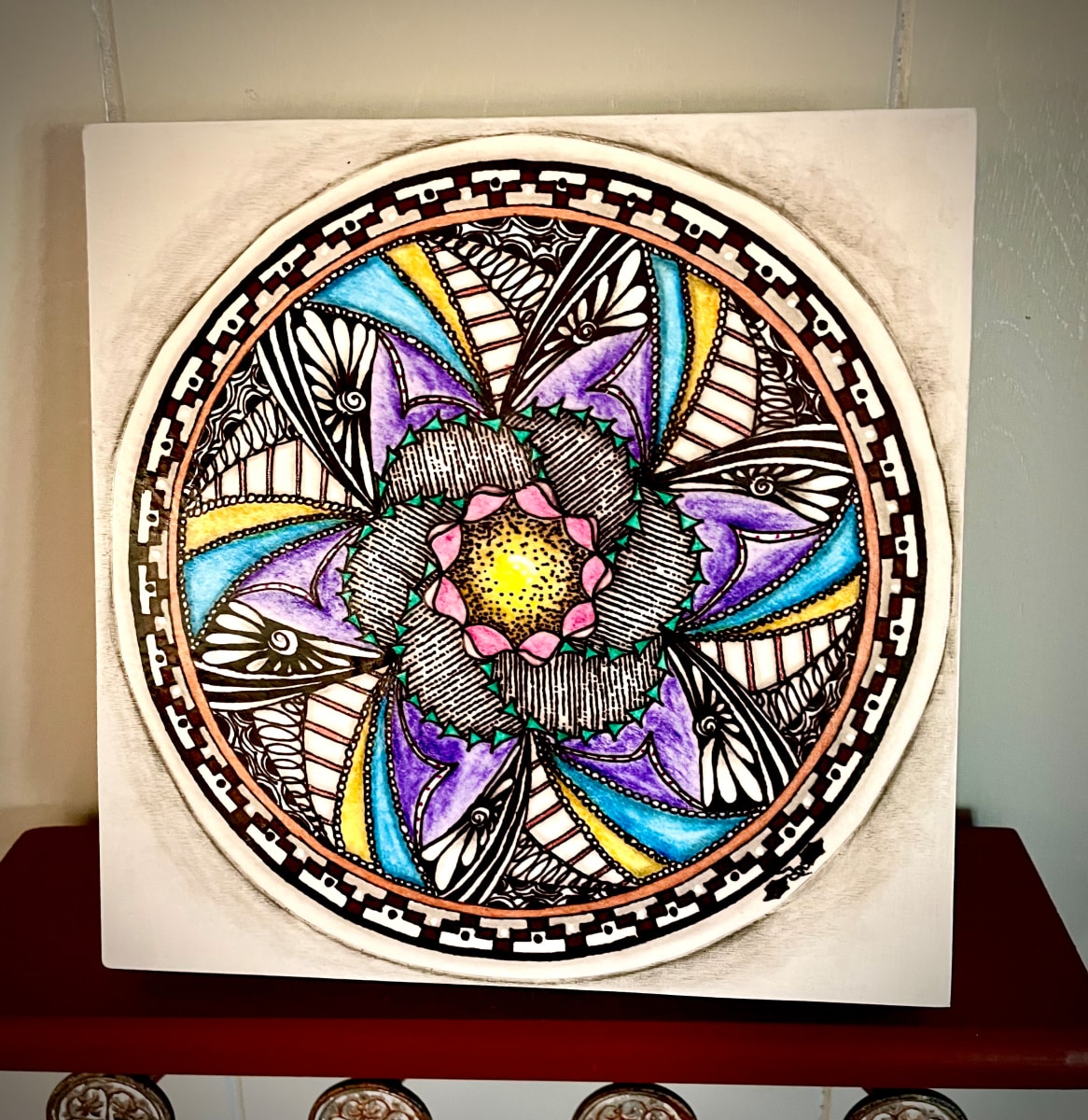 “Flower Within Flower Mandala by Donna Norton  Image: Flower Within Flower Mandala is on an 8” square wood panel. 