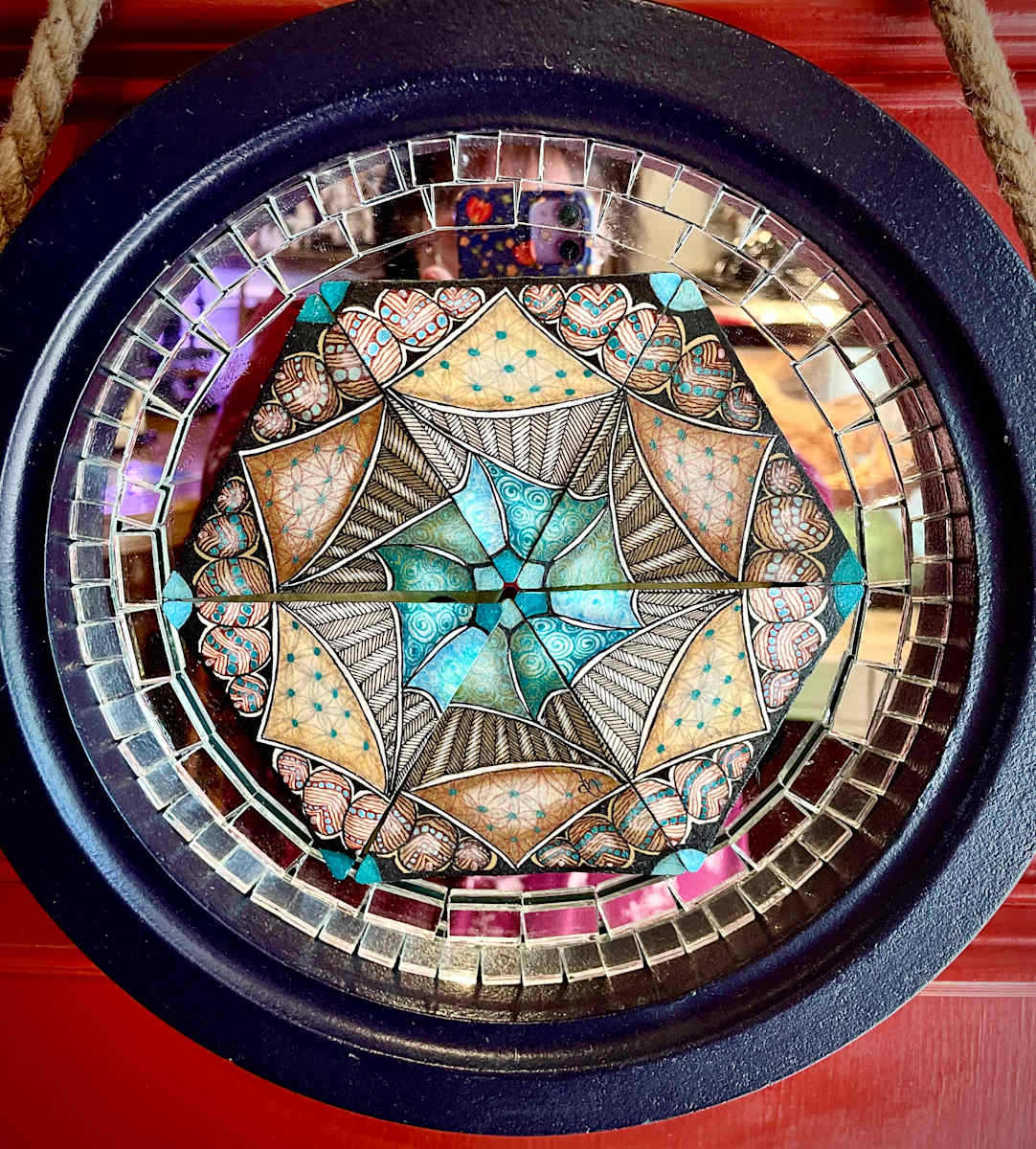 Magical Mirrored Hexagon Tile Series #1 by Donna Norton  Image: Triangular paper tiles on a nautical style framed mirror with small mirrored glass  tiles surrounding. It has a 3D effect in a couple of ways to give be a magical appearance. 