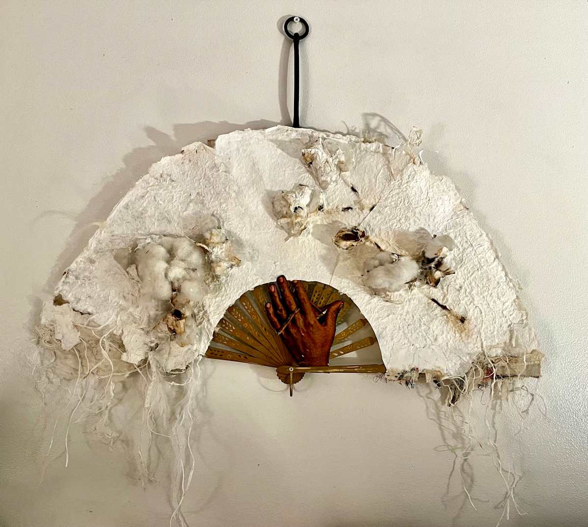 THE FABRIC OF OUR LIVES by ROSALIND NZINGA VAUGHN-NICHOL  Image: THE FABRIC OF OUR LIVES, 2022   
Assemblage handmade paper w/cotton plants, antique fan, metal, and textiles.
30” H x 26” W x 3”D
