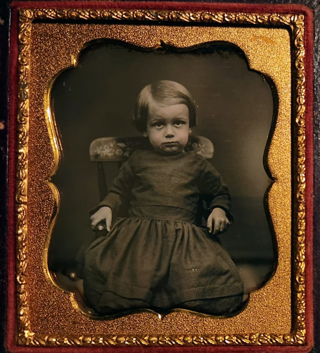 Young boy in stenciled chair and dress 