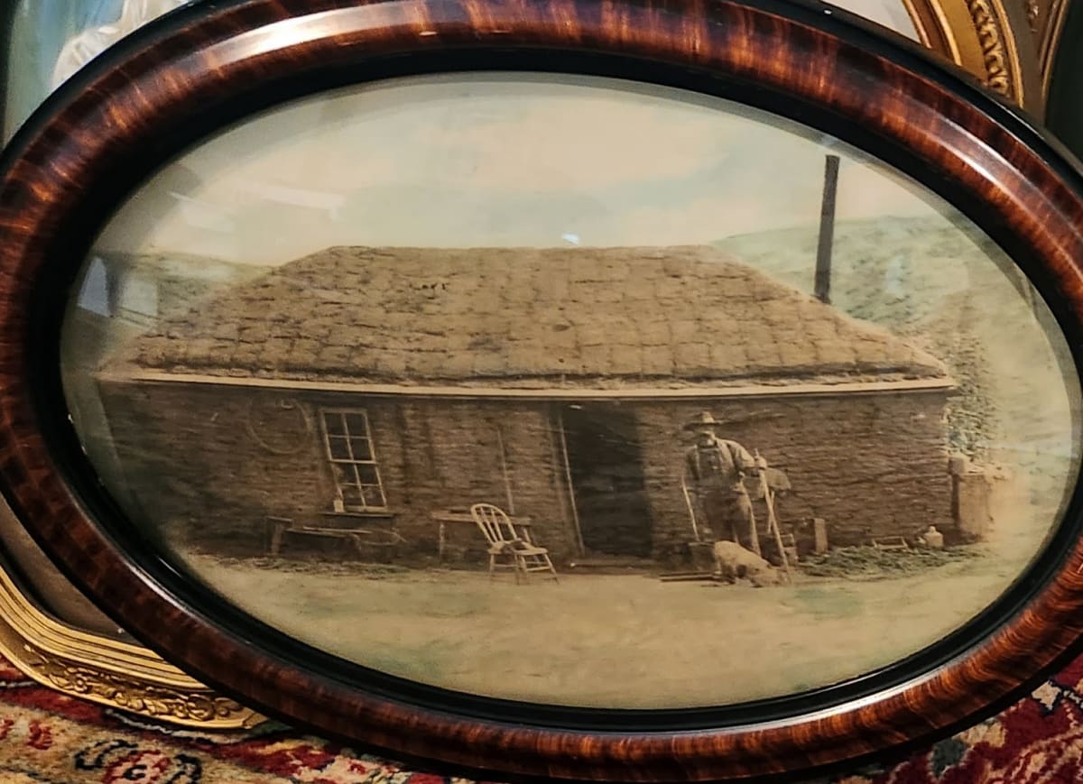 Man in front of sod house 