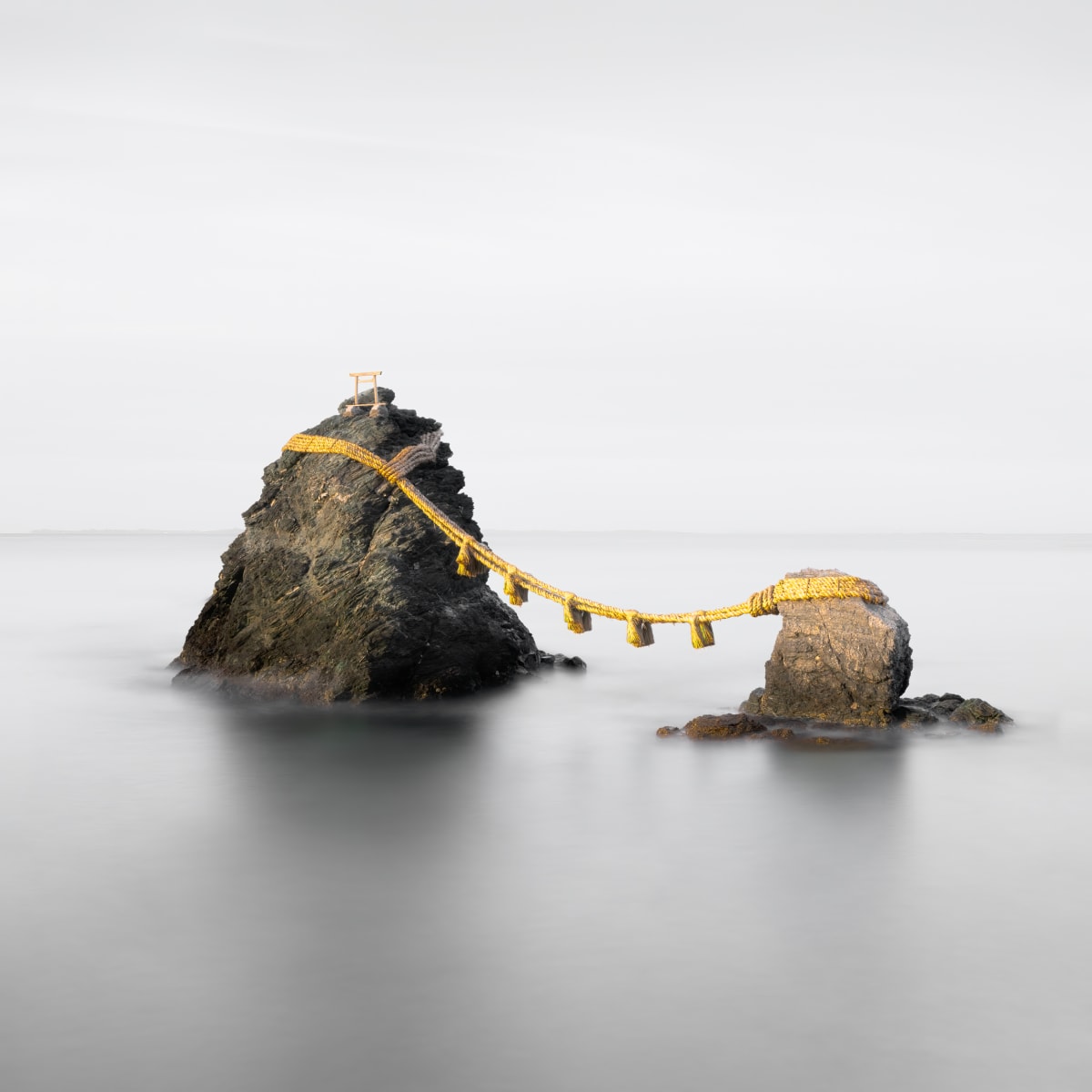 Meoto Iwa by Vera Conley  Image: These sacred Marriage Rocks are linked by a heavy shimenawa rope made of rice straw. They are considered sacred by worshippers at the nearby Shinto shrine.