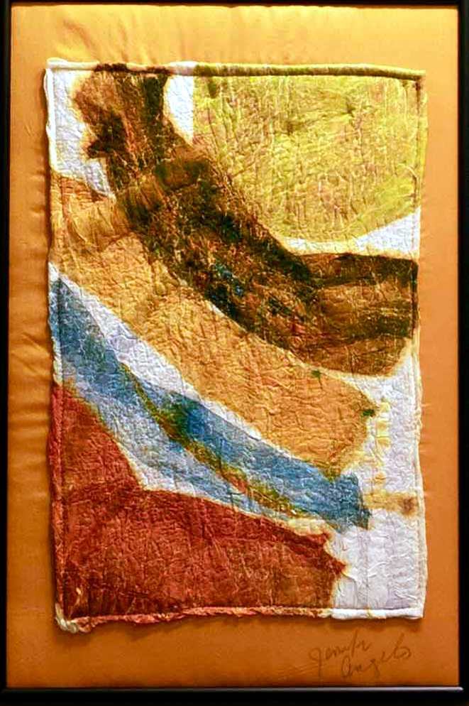 Sunlit Flow by Jennifer Angelo  Image: This vibrant wet-felted artwork presents broad, flowing bands of yellow and earth tones, evoking the warmth and movement of sunlight across a landscape. The layered textures and organic curves of the piece suggest the natural interplay of light and shadow, while the soft edges offer a sense of fluidity. Sunlit Flow invites the viewer to explore the dynamic harmony of color and form, celebrating the beauty found in the simple yet profound passage of light.