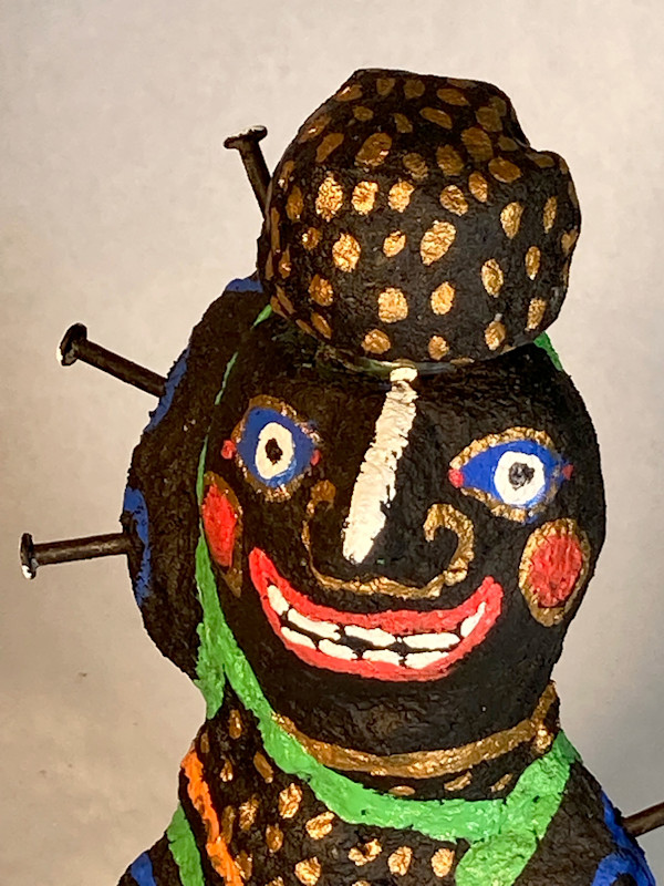 Black face with nails and gold spotted hat by Jennifer Taylor