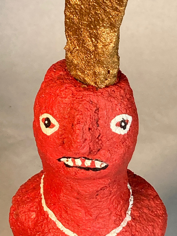 Red face with gold hat and white necklace by Jennifer Taylor