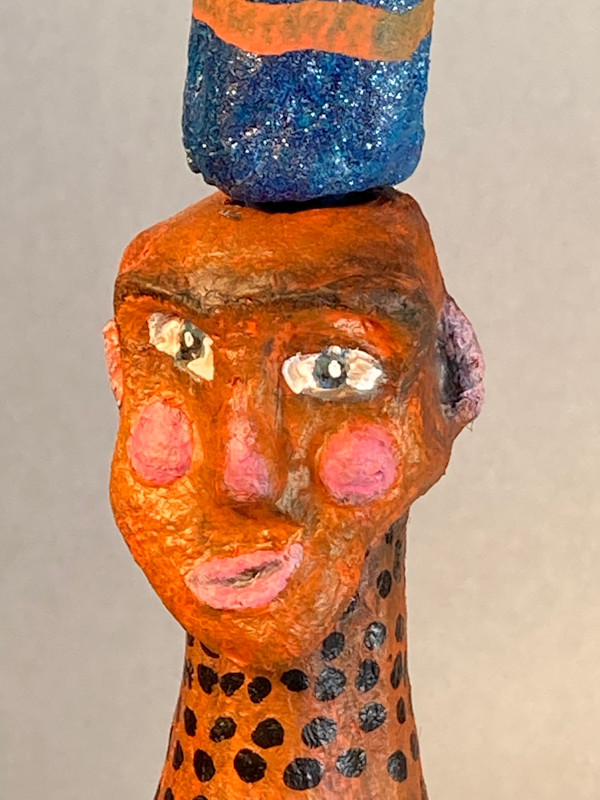 Orange face and blue dress with tall blue hat by Jennifer Taylor